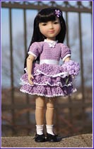 Black-haired little girl doll in light purple ruffled dress
